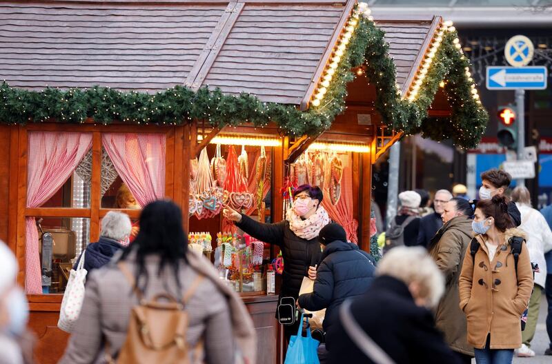 People wearing protective face masks walk beside Christmas-themed food stalls at Schloss Strasse shopping street, amid the coronavirus disease (COVID-19) outbreak in Berlin, Germany, December 1, 2020.    REUTERS/Fabrizio Bensch