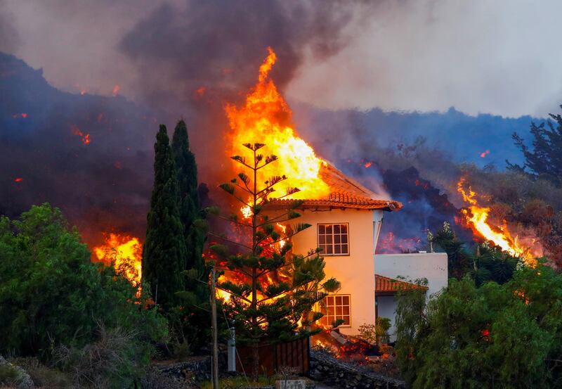 A house catches fire in La Palma as lava flows from the eruption. Photo: Reuters