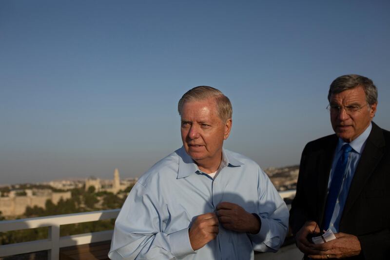 U.S. Sen. Lindsey Graham, R-S.C., takes off a microphone after speaking to journalists in Jerusalem during his visit to Israel, Tuesday, June 1, 2021. (AP Photo/Maya Alleruzzo)