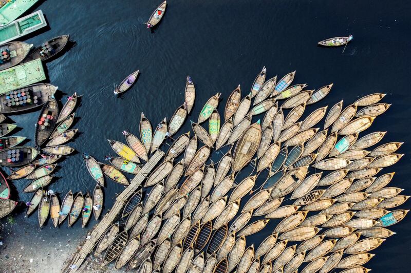 The Aerial picture shows boatmen waiting for passengers docked on the bank of a river during a government-imposed lockdown as a preventive measure against the COVID-19 coronavirus in Dhaka on March 28, 2020. (Photo by Munir UZ ZAMAN / AFP)