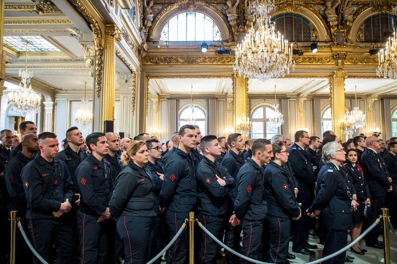 Firefighters' brigade and security forces who took part at the fire extinguishing operations during the Notre Dame of Paris Cathedral fire, listen to French President Emmanuel Macron's speech at Elysee Palace in Paris, France, April 18, 2019. REUTERS
