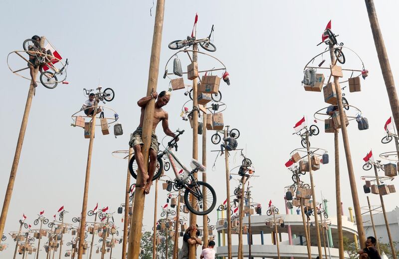 Indonesian participants climb greased poles to collect presents at a pole race during celebrations to mark the 74th anniversary of Indonesia's independence at the Jaya Ancol Dream Park in Jakarta, Indonesia.  EPA