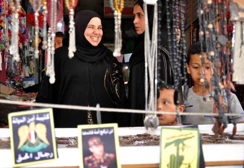 Women and children choose ornaments at a market in Syria's northeastern city of Hasakeh on June 11, 2018.  For the first time in years, the market of Hasakeh is open past dusk ahead of the Eid al-Fitr feast. For some, the resurgent holiday spirit is a sign that the tensions between the Syrian army and Kurdish forces that ruined the festive occasion in previous years are being worked out.
 / AFP / Ayham al-Mohammad
