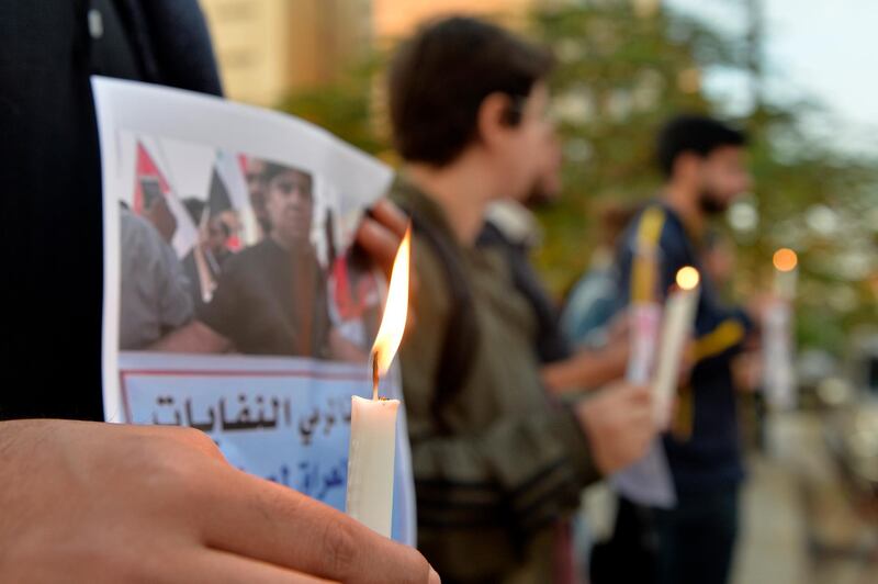 Lebanese activists hold candles during a protest to support children taking part in the uprising in front of the Iraqi embassy in Beirut.  EPA