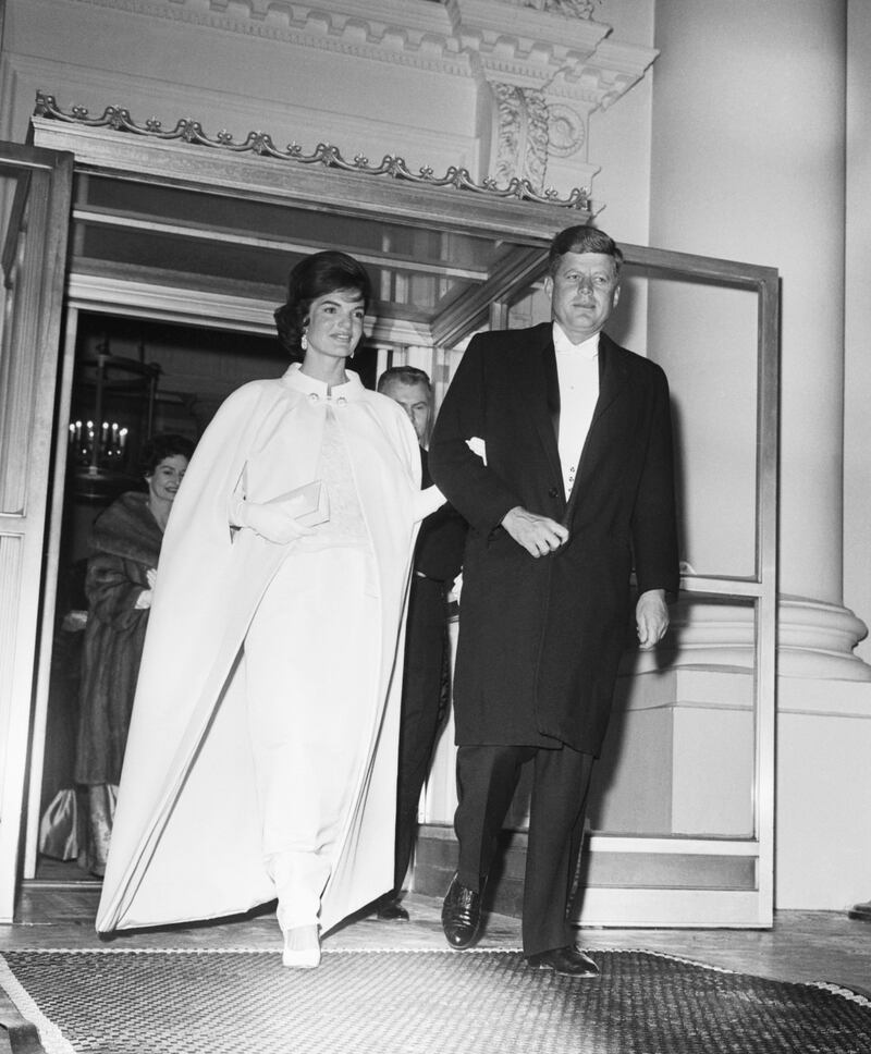 (Original Caption) 1/20/1961-Washington, D.C.: Full length shot of President and Mrs. John F. Kennedy as they left the White House to attend a series of inaugural balls. Five locations were booked to hold the tremendous crowd that wanted to attend. The First Lady's dress was designed by Oleg Cassini.