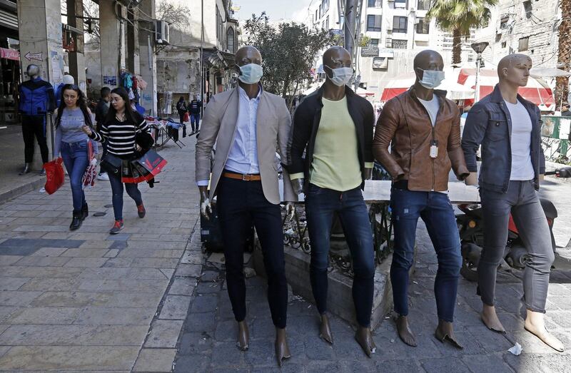 Mannequins are dressed with protective face masks in a street in the Syrian capital Damascus.  AFP