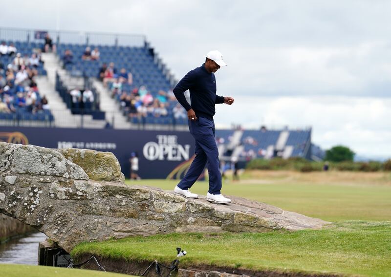 Tiger Woods walks over the Swilcan Bridge. PA