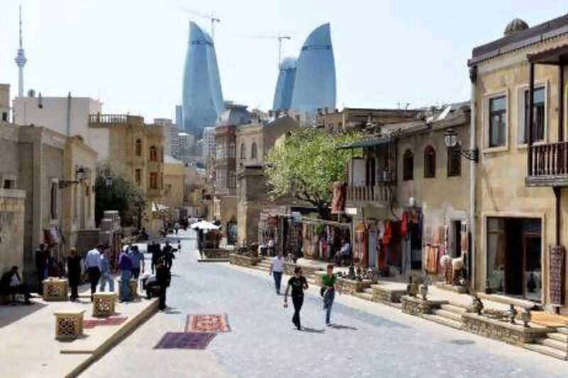 Baku's Old Town is a Unesco heritage site but gleaming new buildings are also cropping up, such as the Flame Towers, in the background. Joern Haufe / AP Photo
