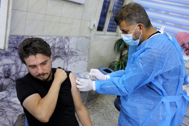 An Iraqi man receives a dose of the Pfizer-BioNTech vaccine in Baghdad.  EPA