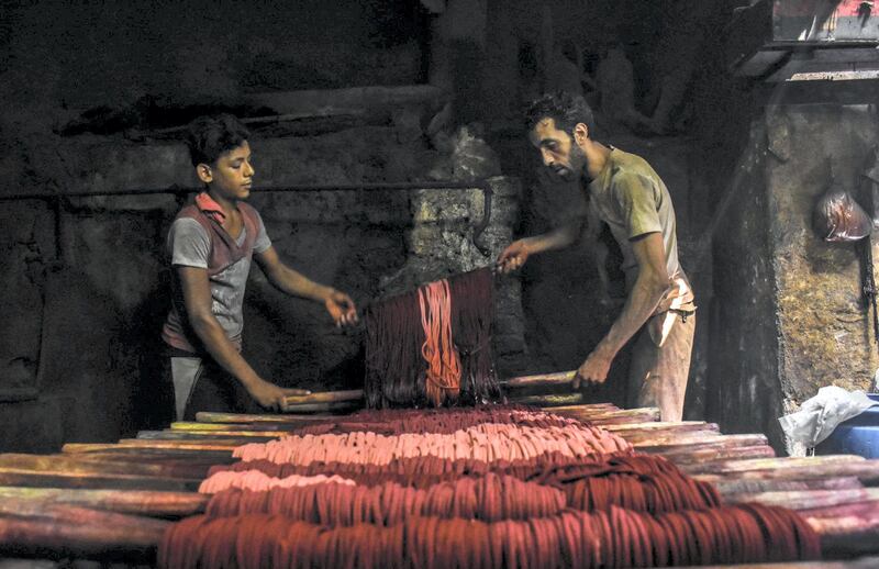 Adham, Egypt: This photo shows two brothers working in their family’s century-old business of weaving colored cotton in the Darb El Ahmar souq in Cairo