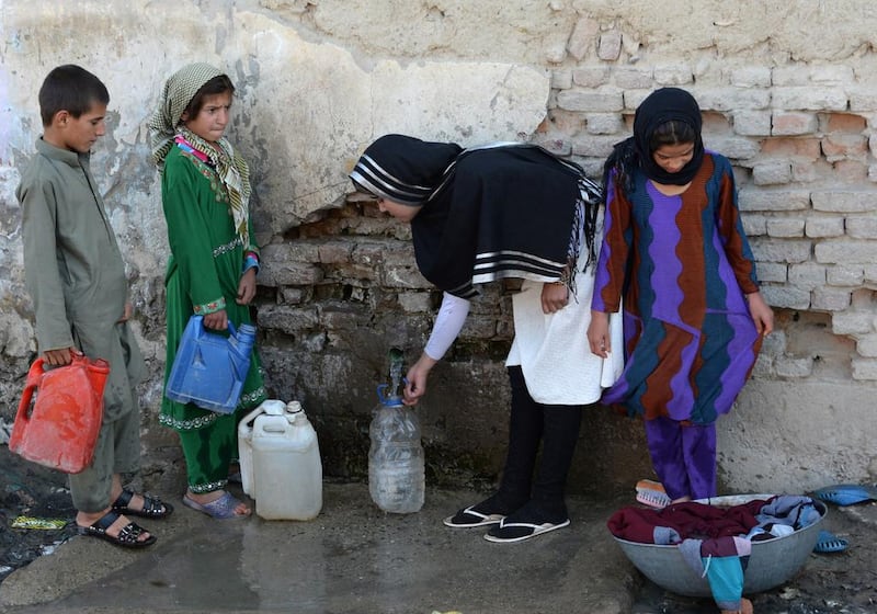 Aziza Rahimzada collects drinking water with slum residents near her temporary home at a refugee camp in Kabul.