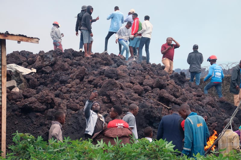 People gather on a stream of cold lava rock following the overnight eruption of Mount Nyiragongo in Goma, Democratic Republic of Congo. AP