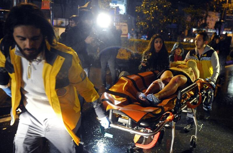 Medics carry a person wounded in the attack. IHA via AP