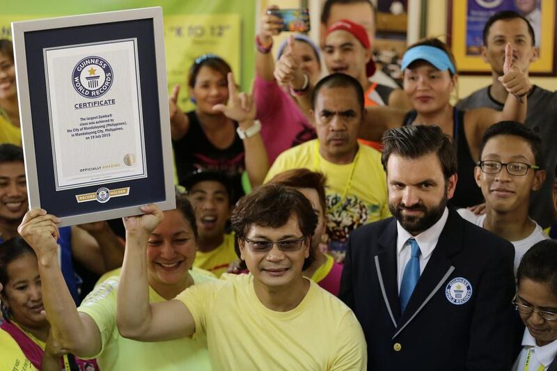 Filipino Mandaluyong city mayor Benhur Abalos, centre, displays the Guinness World Record for having the largest Zumba class certificate next to Guinness adjudicator official Allan Pixley, right, in Mandaluyong city, eastern Manila, Philippines. Francis R Malasig / EPA