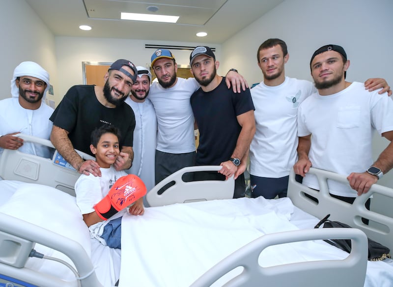 Belal Muhammad, second left, Islam Makhachev, centre, and other members of their teams visit Gaith Al Alawi at the Al Jalila Children's Hospital in Dubai.  All photos Victor Besa / The National