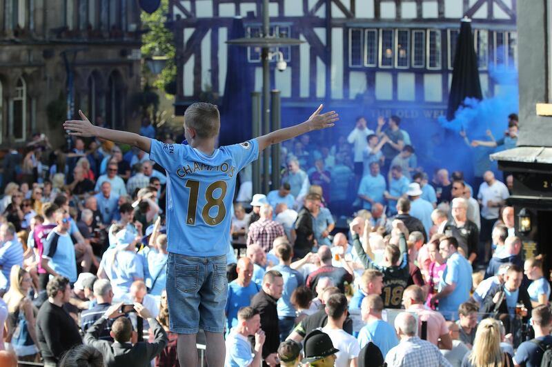 Manchester City fans cheer during the team's bus parade to celebrate their English Premier League title win, in Manchester. Nigel Roddis / EPA