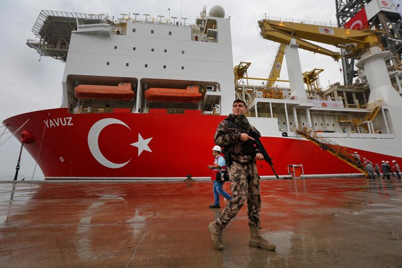 FILE-In this Thursday, June 20, 2019 file photo, a Turkish police officer patrols the dock, backdropped by the drilling ship 'Yavuz' that was dispatched to the Mediterranean, at the port of Dilovasi, outside Istanbul. The Turkish Foreign Ministry said Wednesday, July 10, 2019 it rejects the European Union's statements condemning its efforts to drill for gas in waters off the coast of Cyprus and says the EU cannot be considered an impartial mediator for the divided island. Cyprus says Turkey is encroaching in waters where the country has exclusive economic rights while the European Union warned Turkey of sanctions. (AP Photo/Lefteris Pitarakis, File)