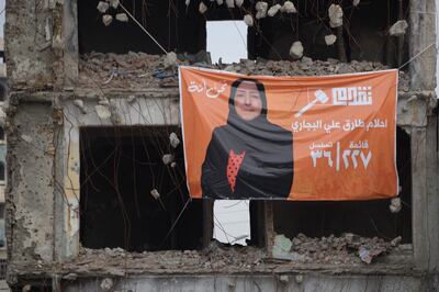 A banner bearing a portrait of Ahlam al-Bijari, a candidate running in Iraq's upcoming local elections in December on a damaged building in the northern city of Mosul. AFP 