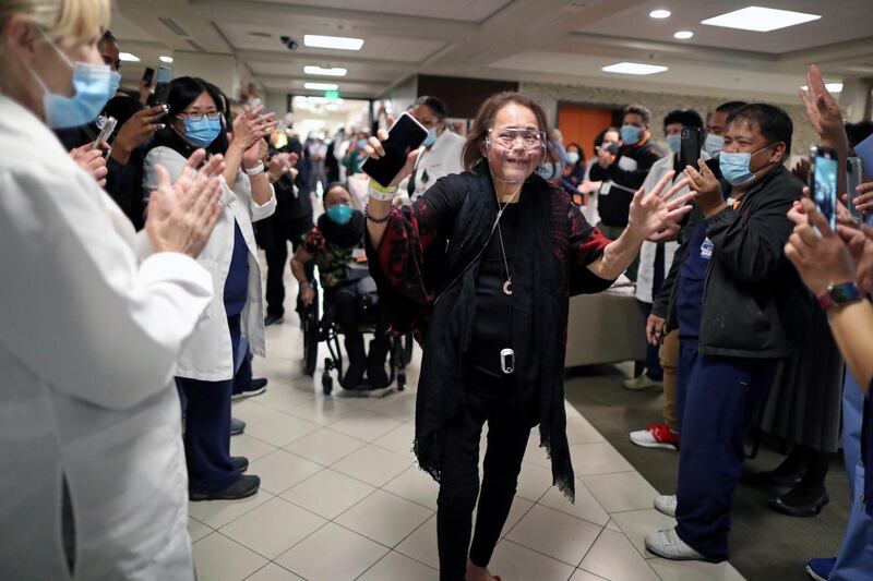 Intensive Care Unit Nurse Merlin Pambuan, 66, is cheered by hospital staff as she walks out of the hospital where she spent eight months with the coronavirus disease, at Dignity Health – St. Mary Medical Centre, in Long Beach, California, US. Reuters