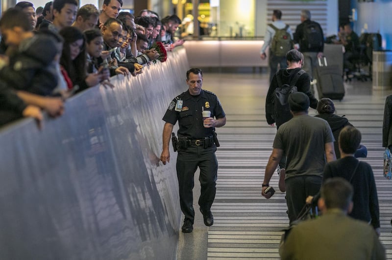 An airport officer walks past international travelers arriving to Los Angeles International Airport on the first day of health screenings for coronavirus of people coming from Wuhan, China in Los Angeles, California. AFP