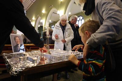 Parishioners light candles at the end of a special service in honour of Sir David Amess at St Michael's and All Angels Church in Leigh-on-Sea, Essex.  (Photo by Adrian DENNIS  /  AFP)