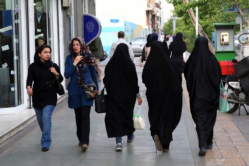 Iranian women walk along a pavement in downtown Tehran. Iran's morality police have announced a new campaign to force women to wear the Islamic headscarf. AP