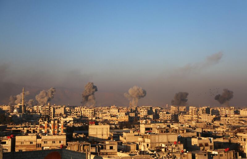 Smoke rises from buildings following air strikes on the rebel-held besieged town of Arbin, in the eastern Ghouta region on the outskirts of the capital Damascus. Amer Almohibany / AFP