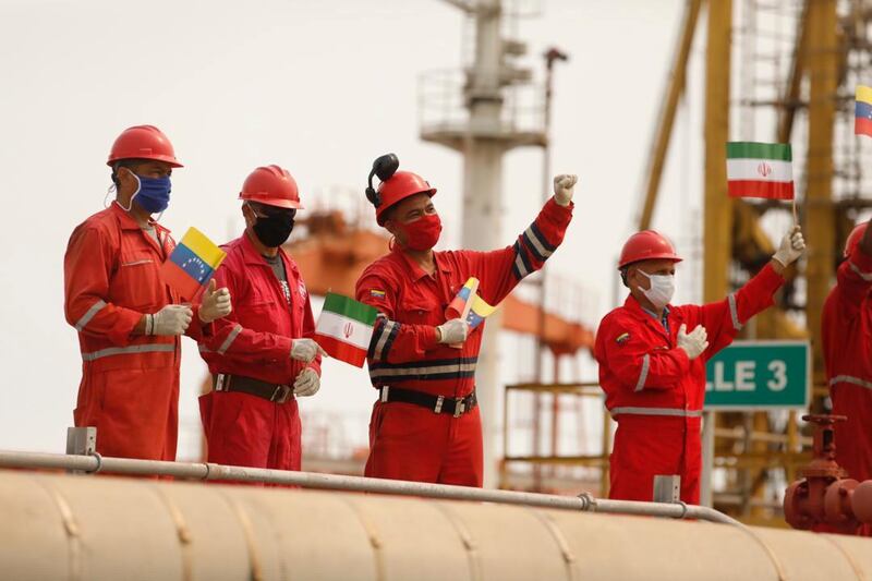 Workers of the state-oil company Pdvsa holding Iranian and Venezuelan flags greet during the arrival of the Iranian tanker ship "Fortune" at El Palito refinery in Puerto Cabello, Venezuela.  Reuters