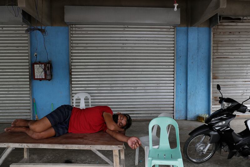 A man rests in front of closed shops in Agoncillo town in Batangas after most residents moved to safer areas.
