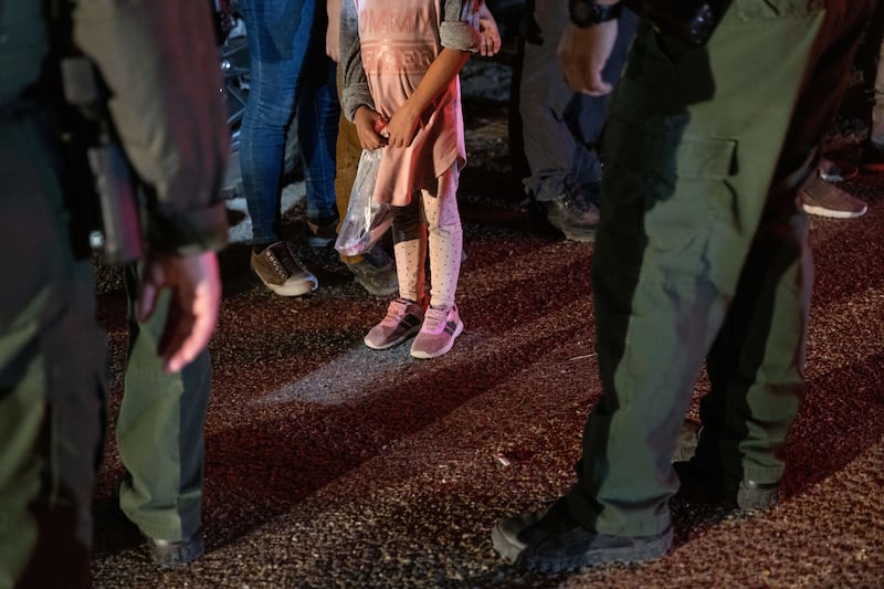 US Border Patrol agents speak to an unaccompanied minor from Honduras after she crossed the Rio Grande from Mexico. Getty / AFP