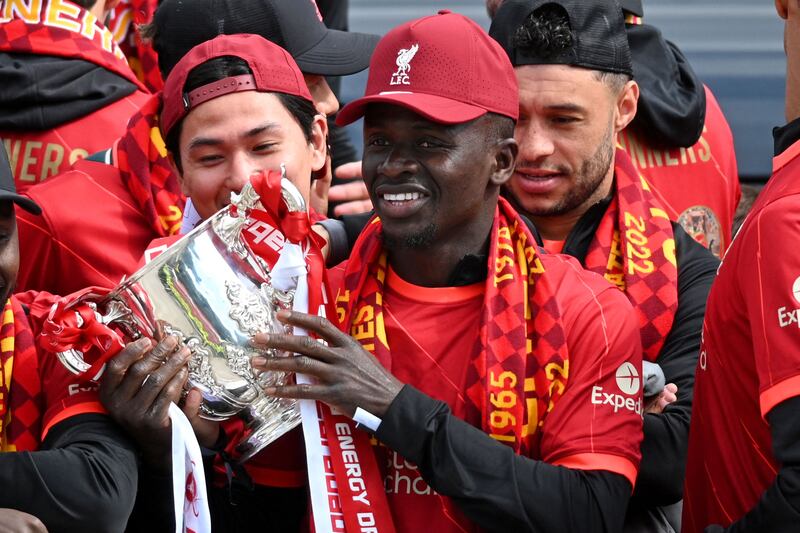 Liverpool's Sadio Mane celebrates with teammates on an open-top bus during a parade through the streets of Liverpool on Sunday, May 29, 2022. The team celebrated winning the League Cup and FA Cup with fans, having lost the Champions League final to Real Madrid. AFP