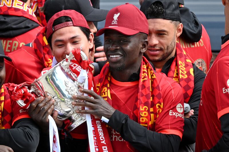 Liverpool's Senegalese striker Sadio Mane celebrates with temmates on an open-top bus during a parade through the streets of Liverpool in north-west England on May 29, 2022, to celebrate winning the 2021-22 League Cup and FA Cup.  - Despite the disappointment of losing to real Madrid in the final of the UEAF Champions League, Klopp has called on Liverpool fans to take to the streets of the city on Sunday when they parade the League Cup and FA Cup.  (Photo by Oli SCARFF  /  AFP)