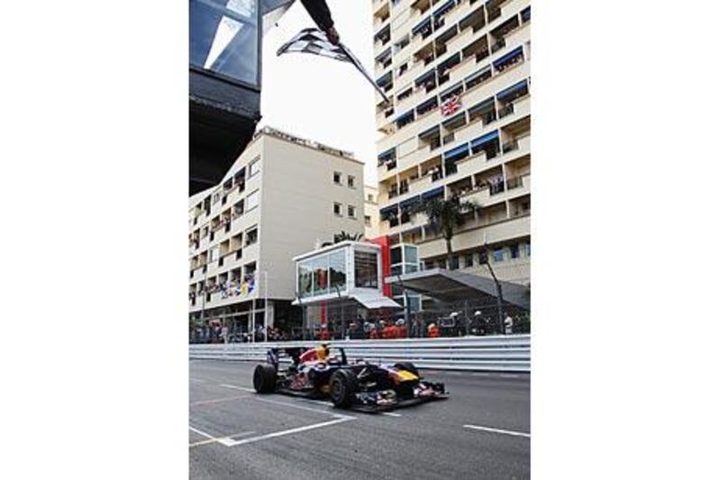 Mark Webber takes the chequered flag as he crosses the finish line in Monte Carlo yesterday.