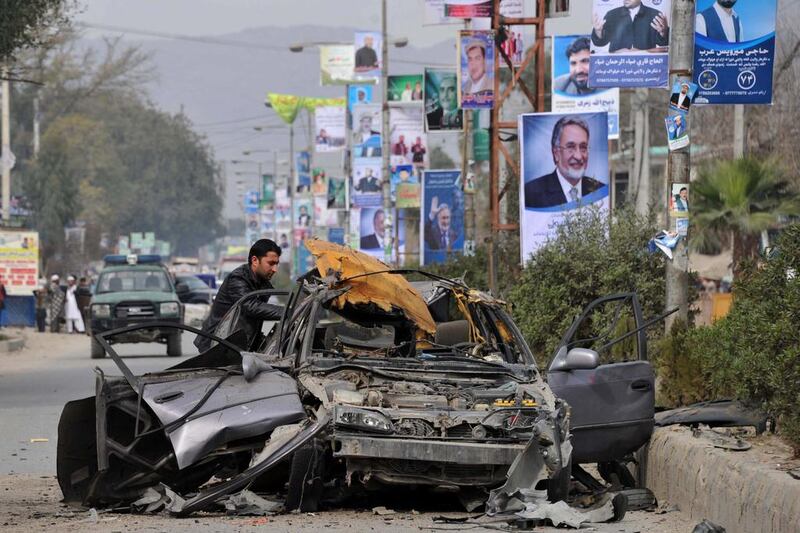 An official inspects a destroyed vehicle belonging to Noor Agha Kamran, district governor for Nazyan, in Afghanistan's Nangarhar province after it exploded in Jalalabad on March 8, killing him and wounding six others. Kamran Noorullah Shirzada / AFP PHOTO

