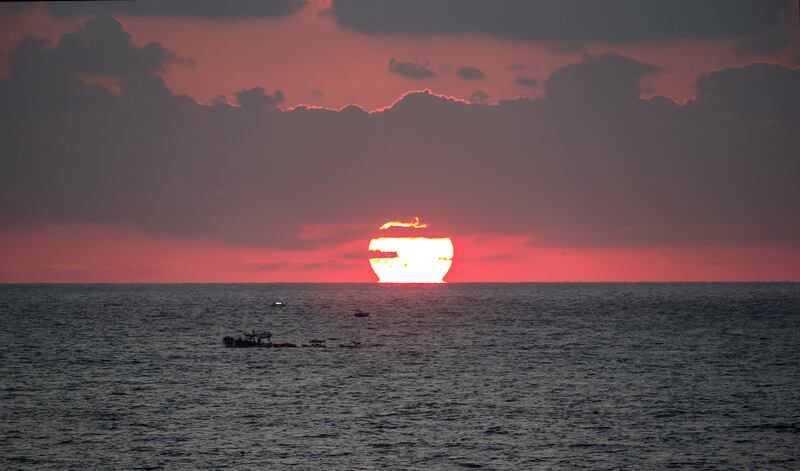 Palestinian fishermen at sea off Gaza city at sunset. EPA