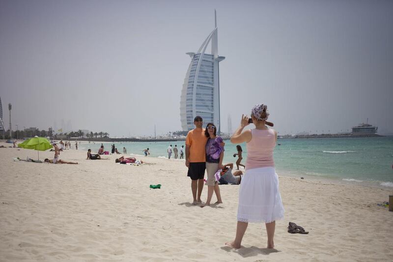Tourists from Turkey taking pictures at the public beach by Burj Al Arab. Razan Alzayani / The National