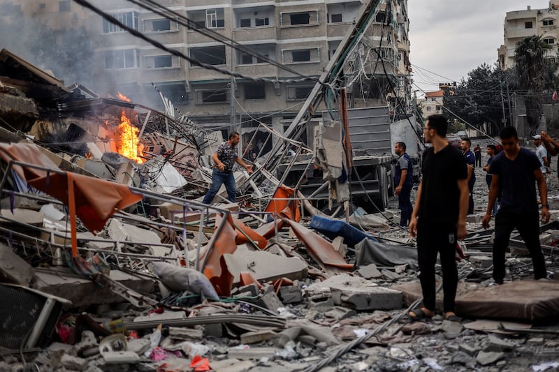 A fire burns among the rubble of a damaged residential building in Gaza city. Reuters