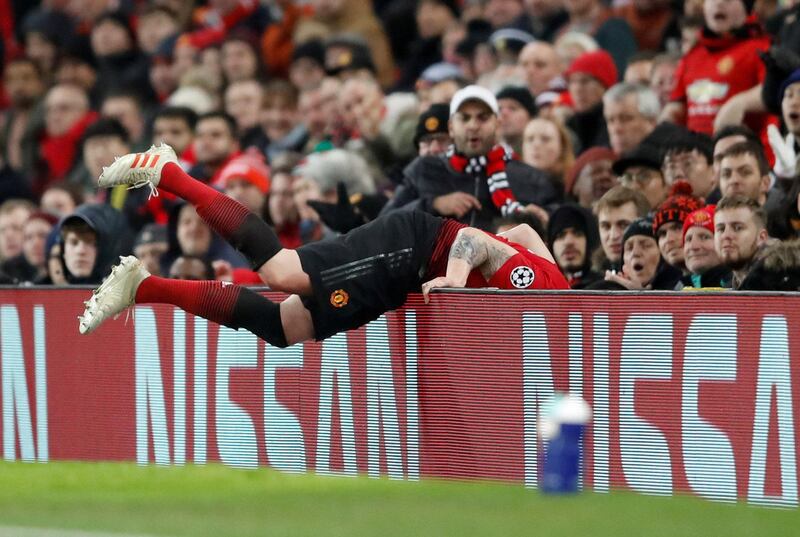 Manchester United's Phil Jones collides with the advertisement board during the match. Reuters