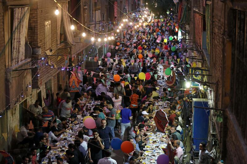 Residents of Ezbet Hamada in Cairo's Mataria district gather for iftar. EPA
