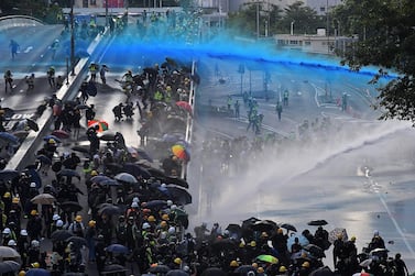 Pro-democracy protesters react as police fire water cannons outside the government headquarters in Hong Kong on Sunday. AFP