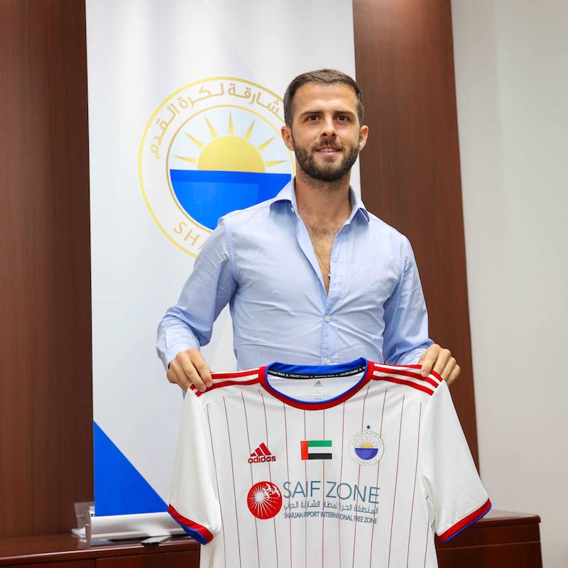 Miralem Pjanic poses with a Sharjah FC shirt after completing his move to the UAE club. Photo: Sharjah FC
