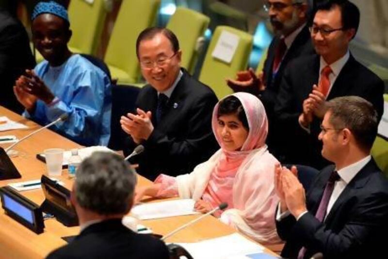 Malala Yousafzai is greeted by the UN secretary general Ban Ki-moon, second from left, Vuk Jeremic, right, president of the UN General Assembly, and Gordon Brown, back to camera, the UN special envoy for global education, at the UN headquarters during the UN Youth Assembly. Stan Honda / AFP