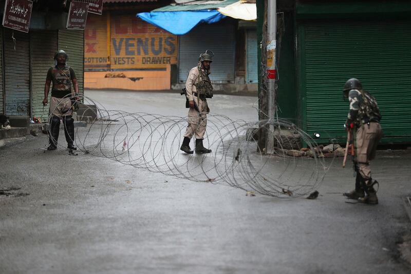 Indian paramilitary soldiers close a street using barbwire in Srinagar, Indian controlled Kashmir, Saturday, Aug. 10, 2019. Authorities enforcing a strict curfew in Indian-administered Kashmir will bring in trucks of essential supplies for an Islamic festival next week, as the divided Himalayan region remained in a lockdown following India's decision to strip it of its constitutional autonomy. The indefinite 24-hour curfew was briefly eased on Friday for weekly Muslim prayers in some parts of Srinagar, the region's main city, but thousands of residents are still forced to stay indoors with shops and most health clinics closed. All communications and the internet remain cut off. (AP Photo/Mukhtar Khan)