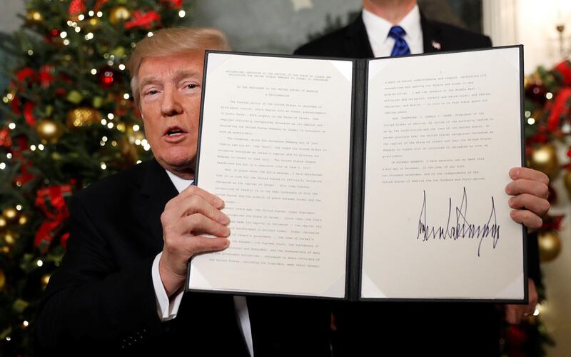 U.S. President Donald Trump holds up the proclamation that announces the United States recognizing Jerusalem as the capital of Israel and moving its embassy there, during an address from the White House in Washington, U.S., December 6, 2017.  REUTERS/Kevin Lamarque