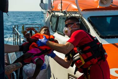 Maltese Armed Forces help a child to board their ship from the German humanitarian vessel Alan Kurdi on Sunday. AP