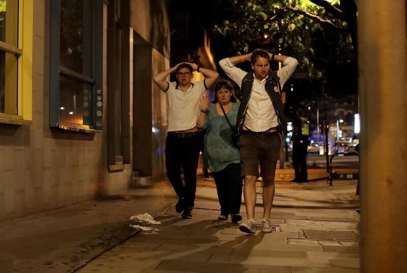 People with their hands on their heads about 10 minutes after midnight as they leave from inside a police cordon after the attack in London. Matt Dunham / AP Photo