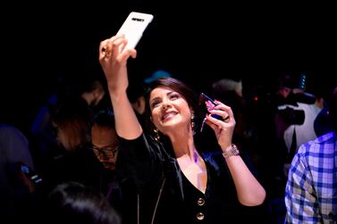 A member of the media takes a selfie while holding s Samsung Galaxy Z Flip phone. AFP