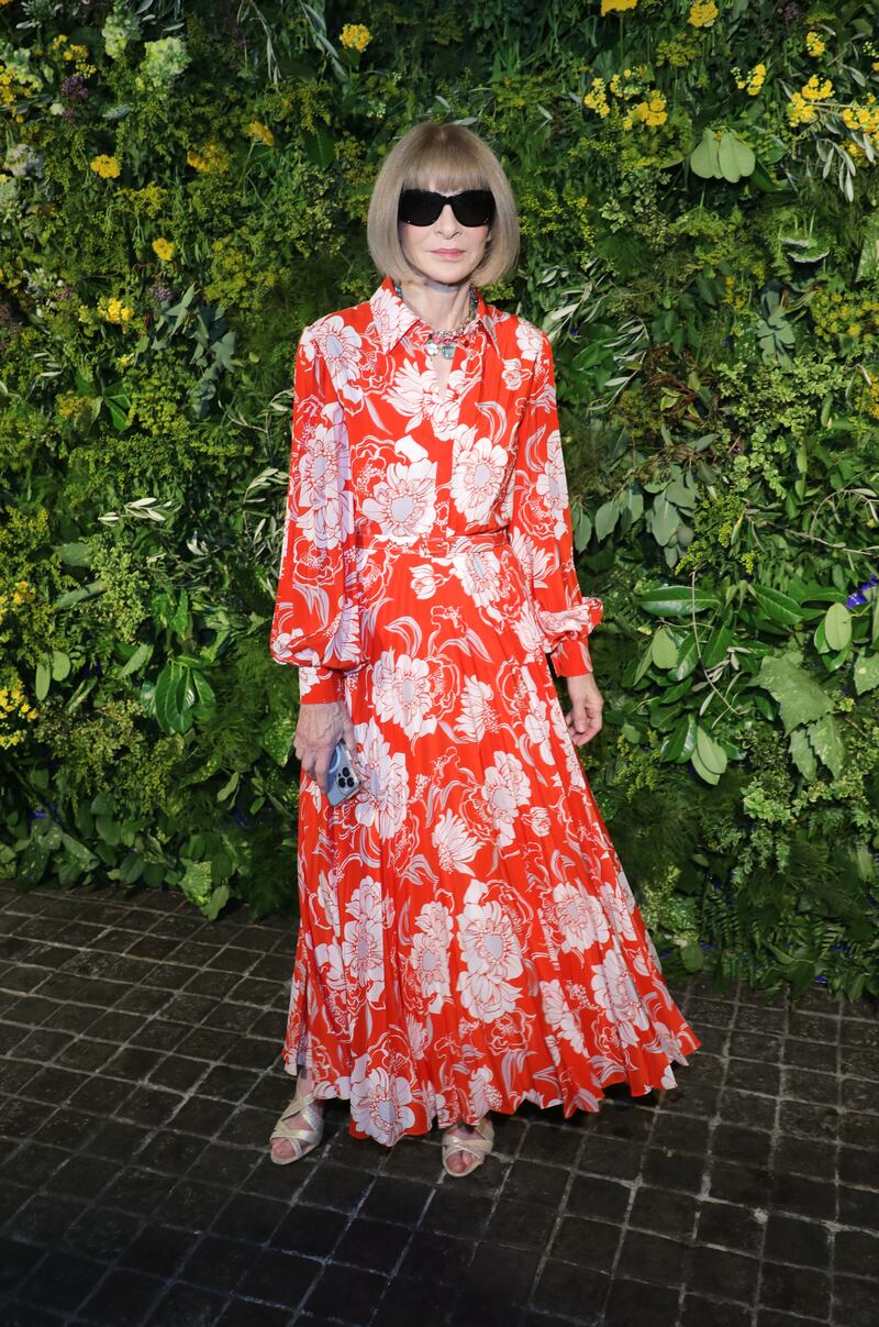 Editor-in-chief of 'Vogue' and chief content officer of Conde Nast, Anna Wintour, attends in a red floral shirt dress.