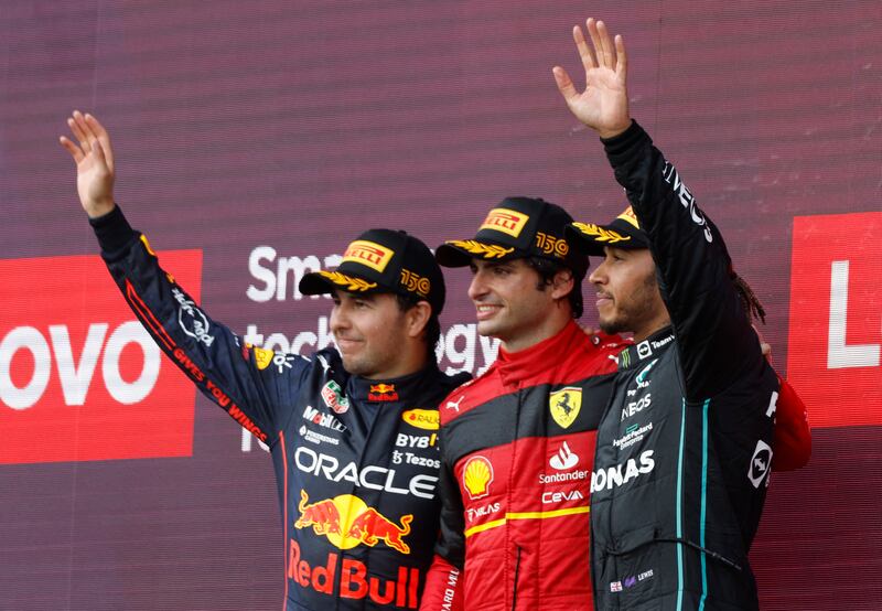 Carlos Sainz celebrates on the podium with second-placed Red Bull driver Sergio Perez and third-placed Lewis Hamilton of Mercedes. Reuters