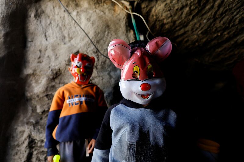Palestinian children wear masks in the cave where they live in Masafer Yatta.